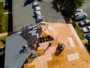 Roofing contractors working on a roof replacement of apartment complex